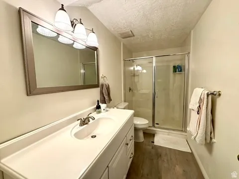 Bathroom featuring a single vanity with integrated sink, brushed nickel faucet, framed mirror, and a shower with glass enclosure