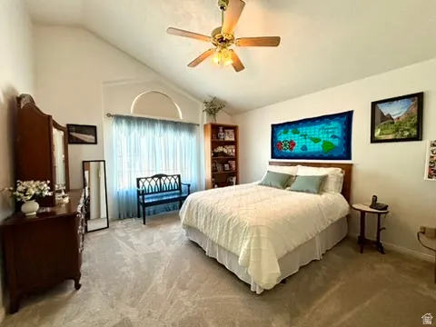 Vaulted ceilings highlight this carpeted room featuring a ceiling fan with integrated lighting