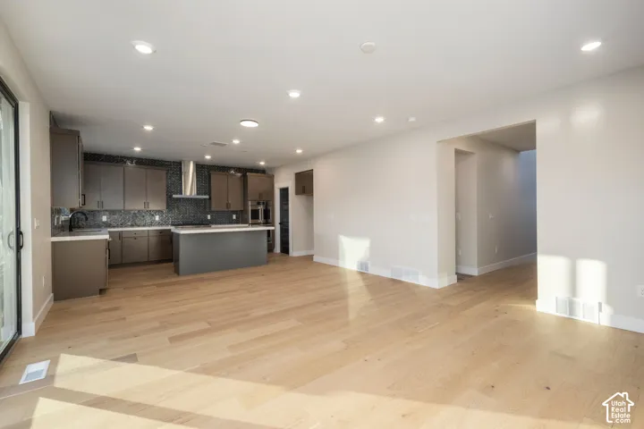 Spacious open concept living area featuring light wood-finish flooring and recessed lighting