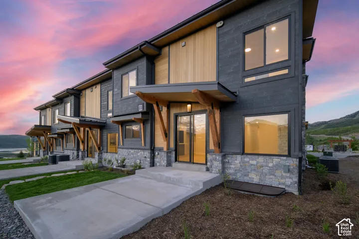 Modern townhome exteriors featuring dark siding, natural wood accents, and stone veneer foundations