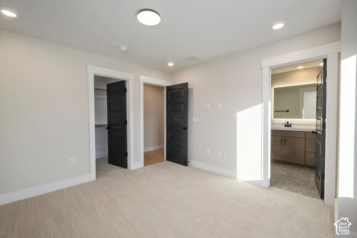 Carpeted bedroom with recessed lighting, white walls, and white trim