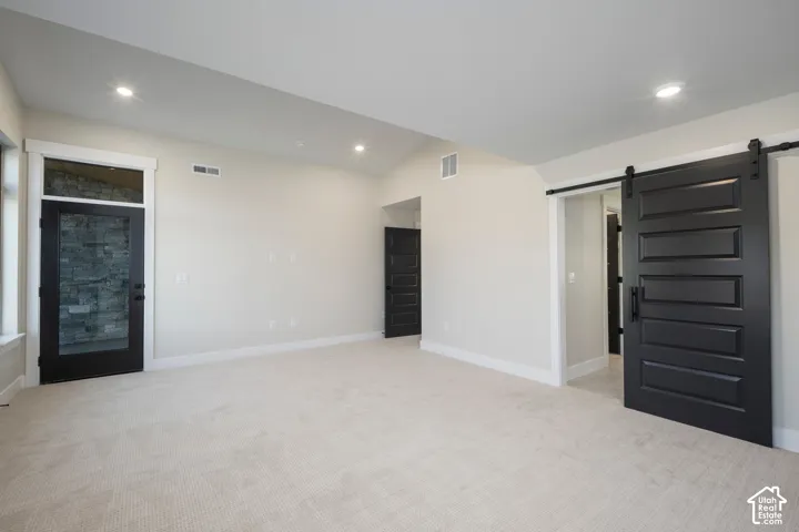 Spacious room featuring light-toned carpeting and neutral wall tones