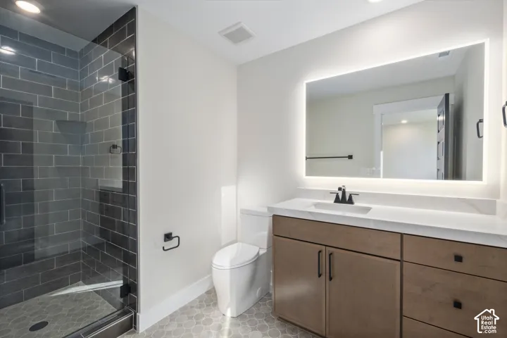 Modern bathroom featuring a glass-enclosed shower with subway tile surround and hexagonal floor tile