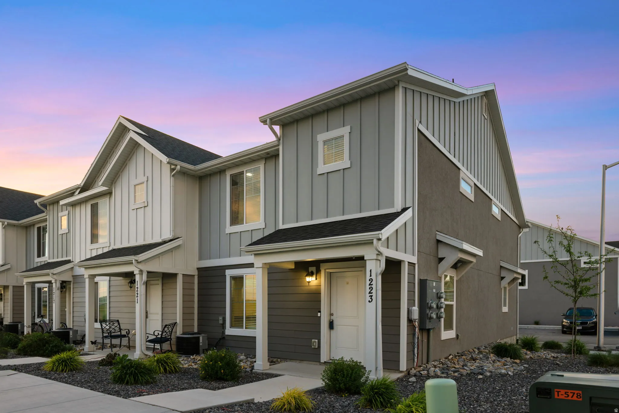 Contemporary townhouse exterior featuring a covered entry, mixed siding, and a gabled roofline