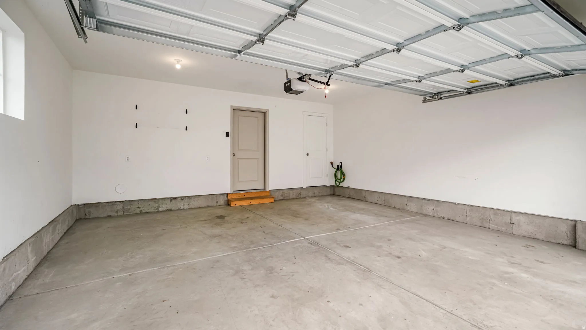 Spacious garage featuring a concrete floor, painted walls, and an overhead door