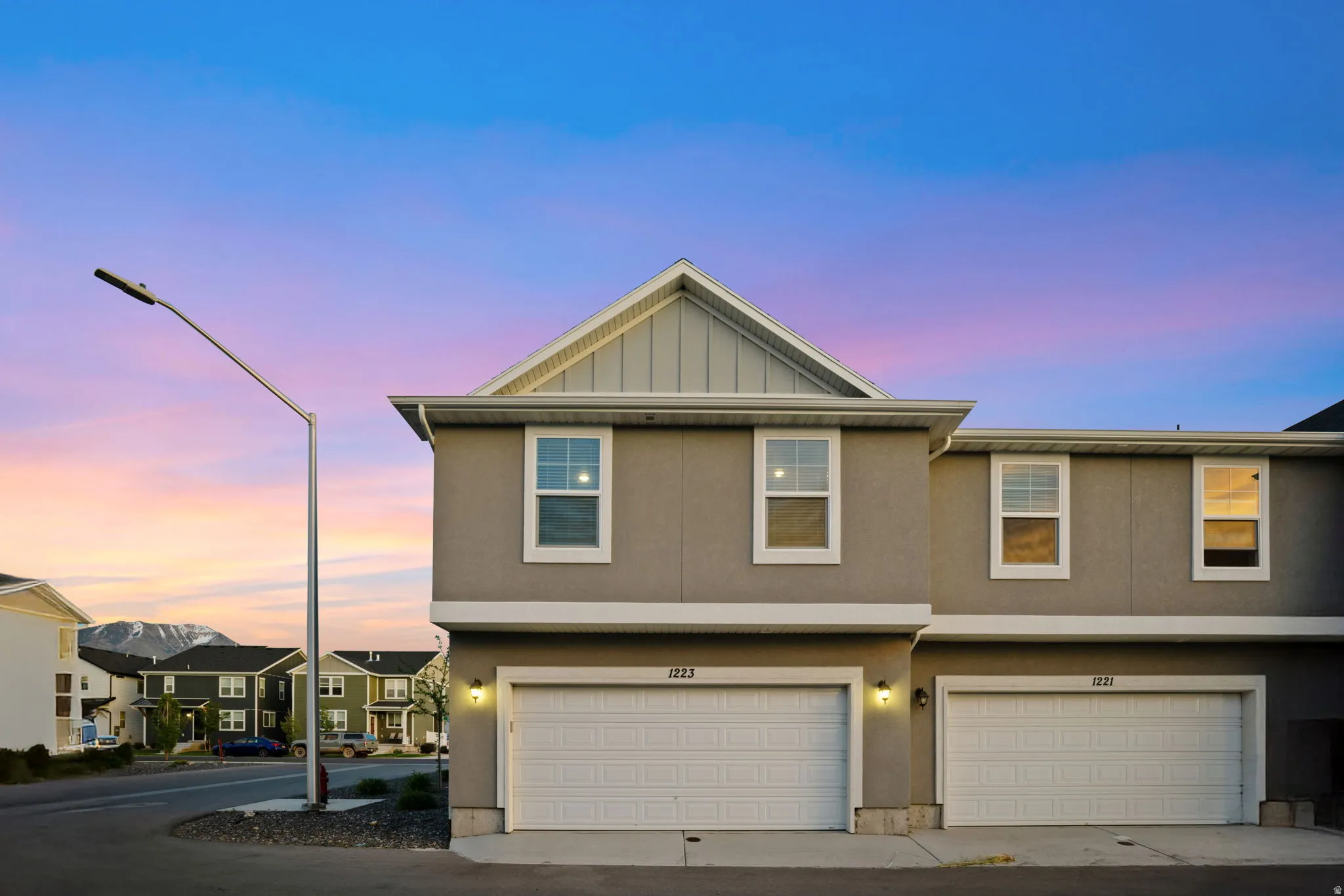 Modern townhome exterior featuring a neutral stucco finish and white trim