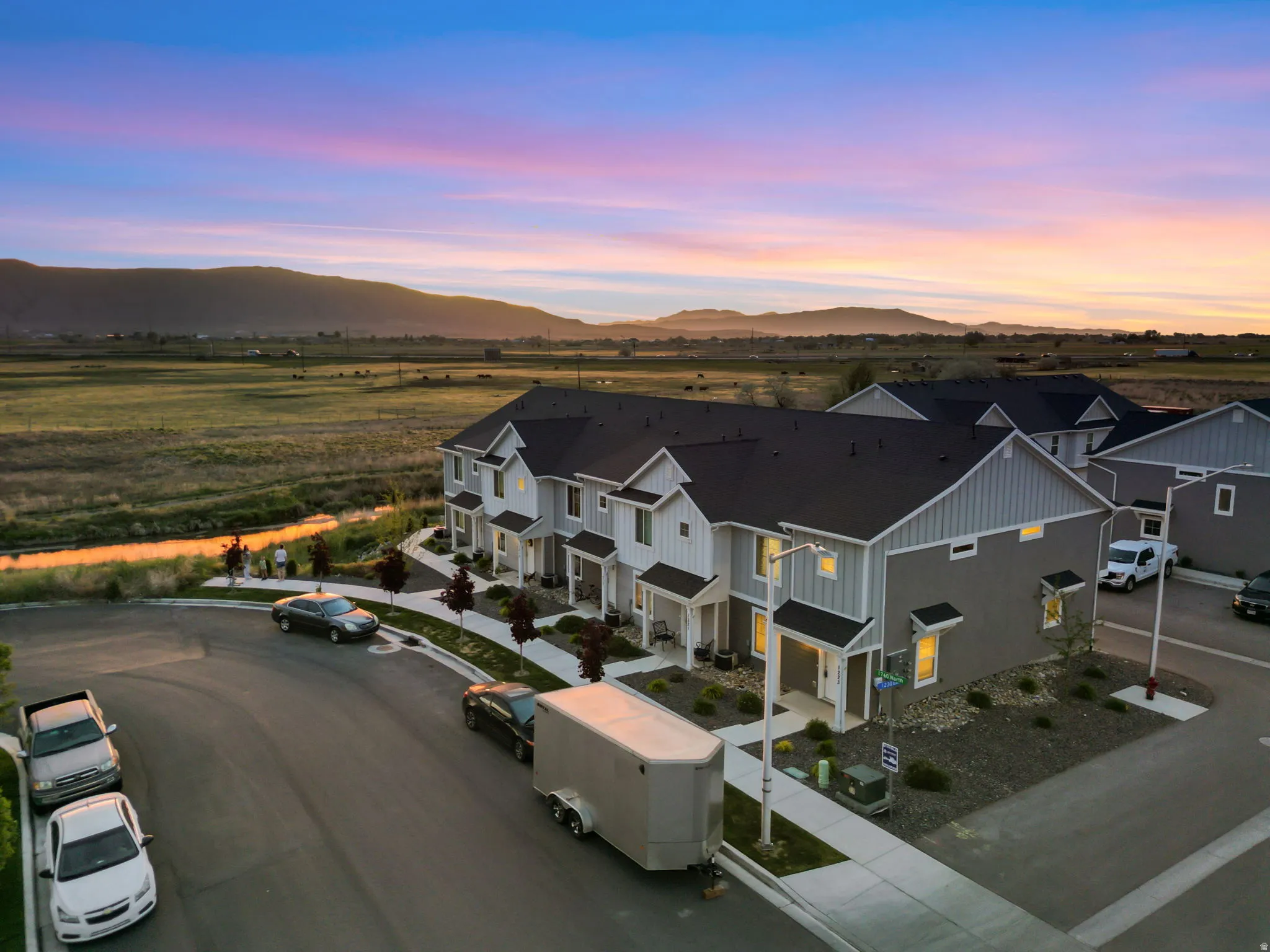 Modern townhome facade featuring light grey siding, white trim, and dark rooflines