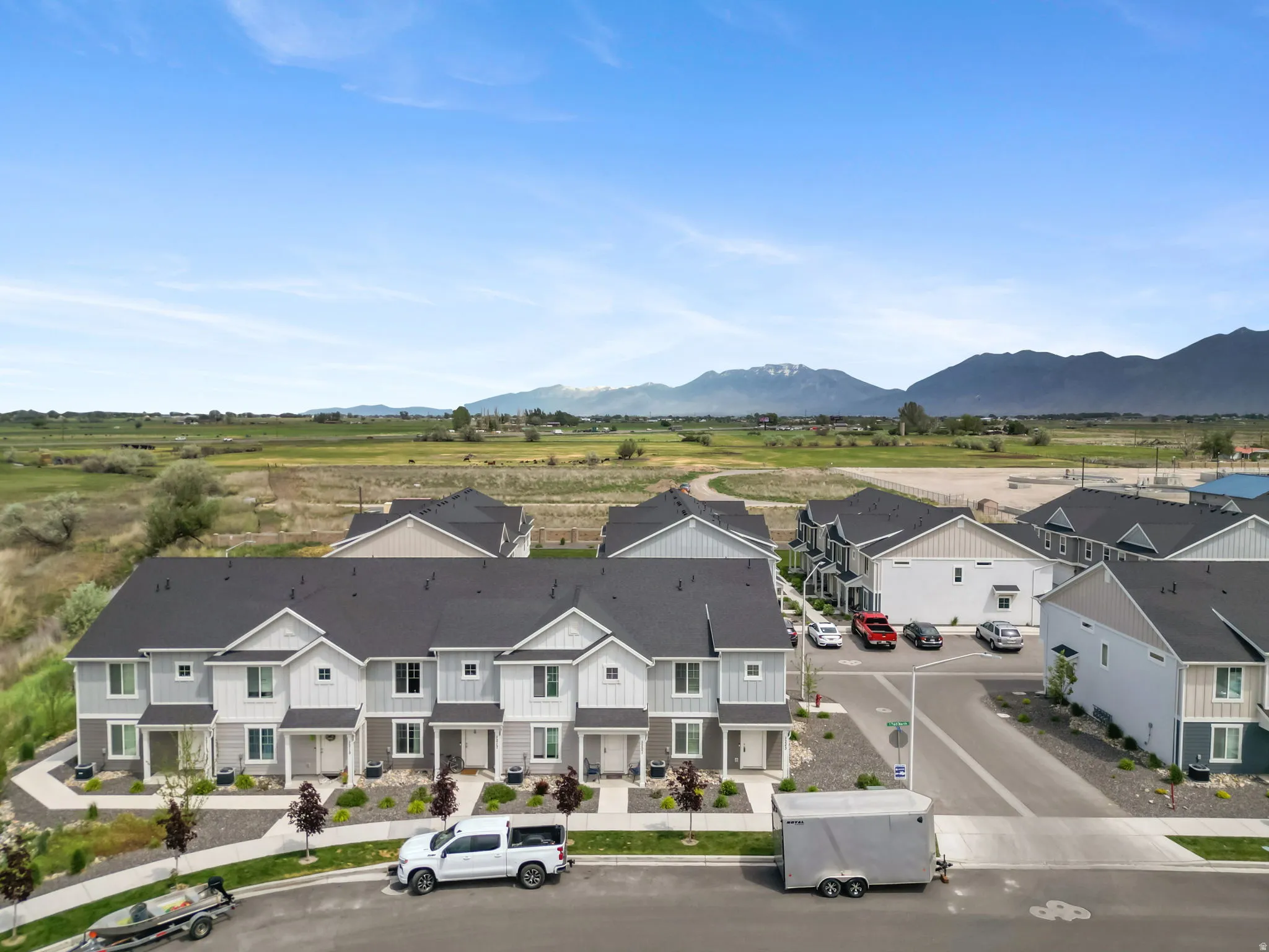 Modern townhome development featuring light-toned exteriors with dark roofing