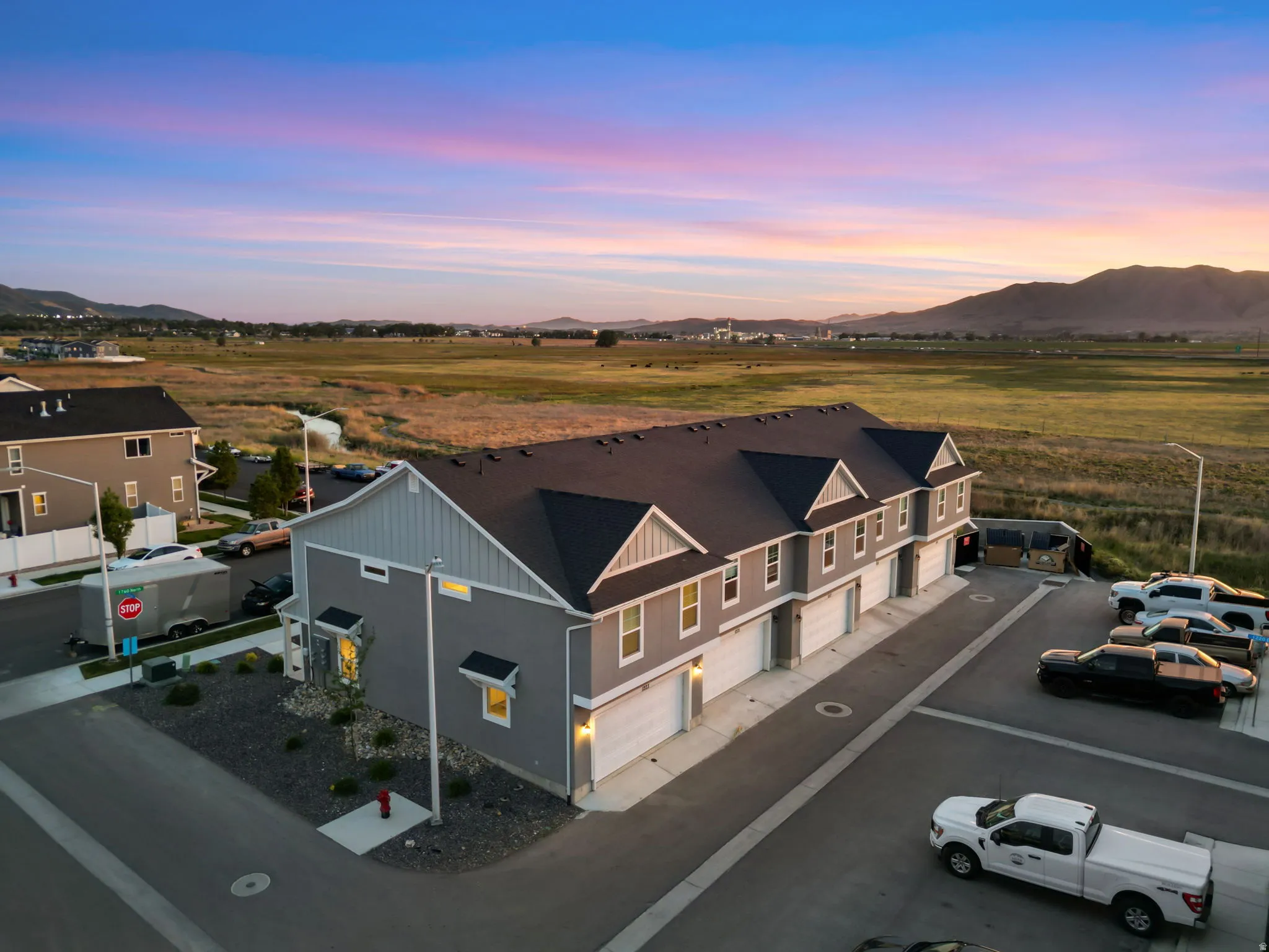 Contemporary townhome-style residences featuring gray siding, white trim, and dark roofing