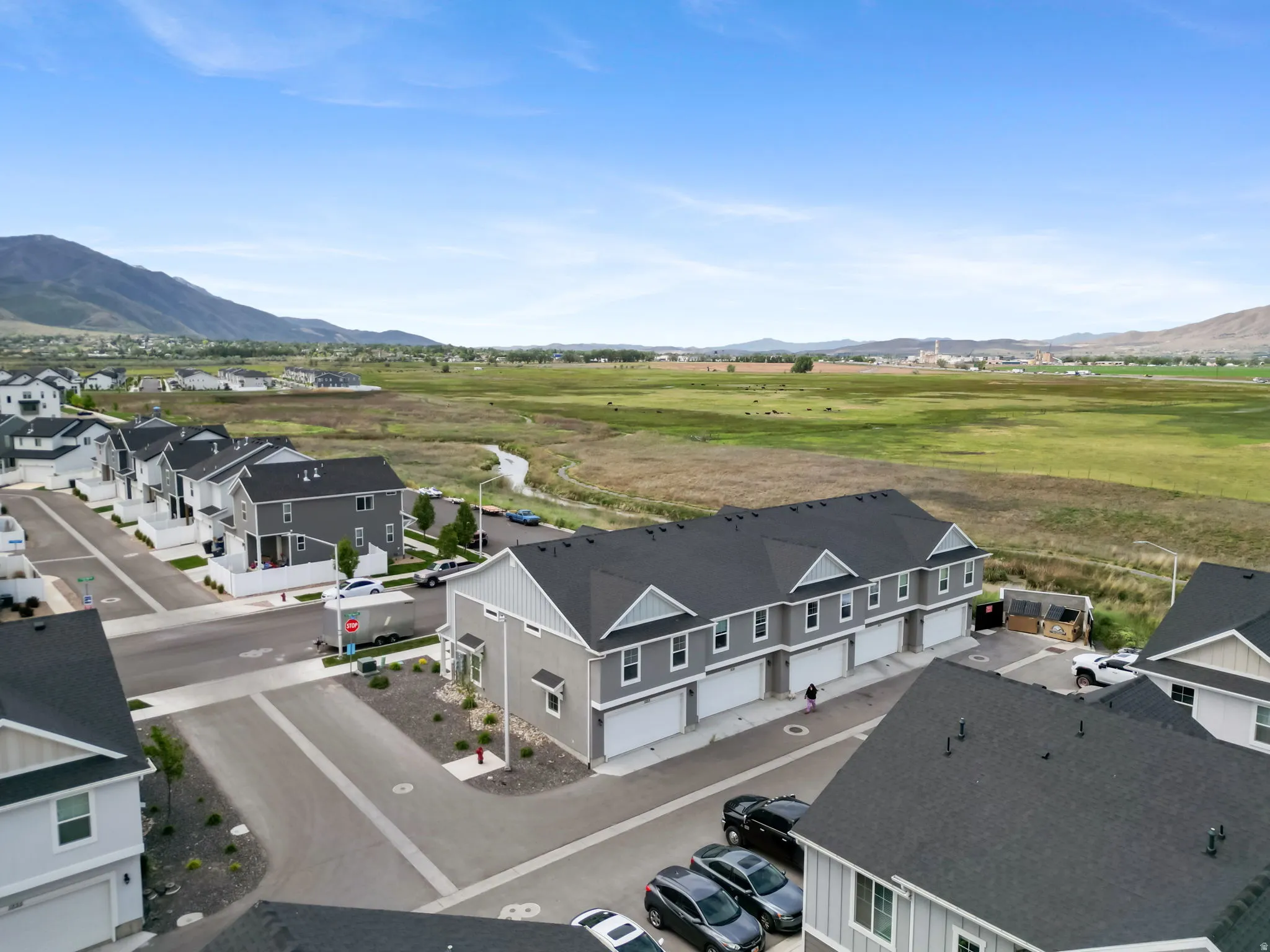 New construction townhome development featuring light gray siding and dark shingle roofing