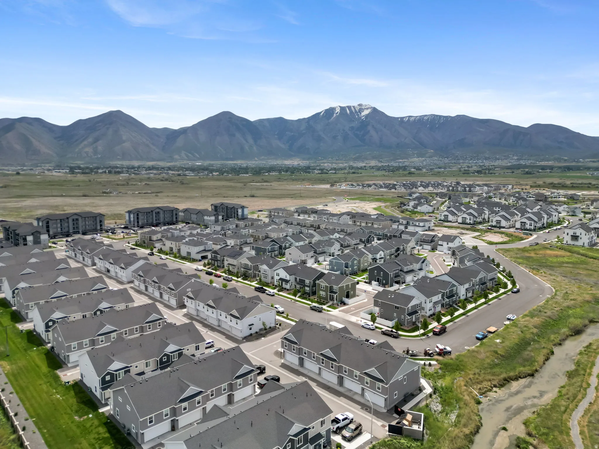 Aerial perspective of a contemporary residential development featuring multiple housing units with gray roofs and varied siding