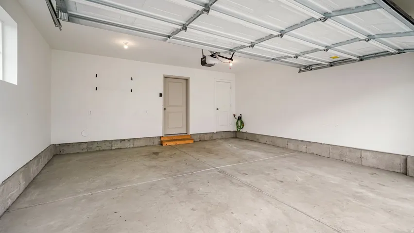 Spacious garage featuring a concrete floor, painted walls, and an overhead door