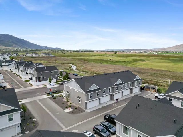 New construction townhome development featuring light gray siding and dark shingle roofing
