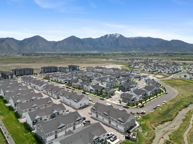 Aerial perspective of a contemporary residential development featuring multiple housing units with gray roofs and varied siding