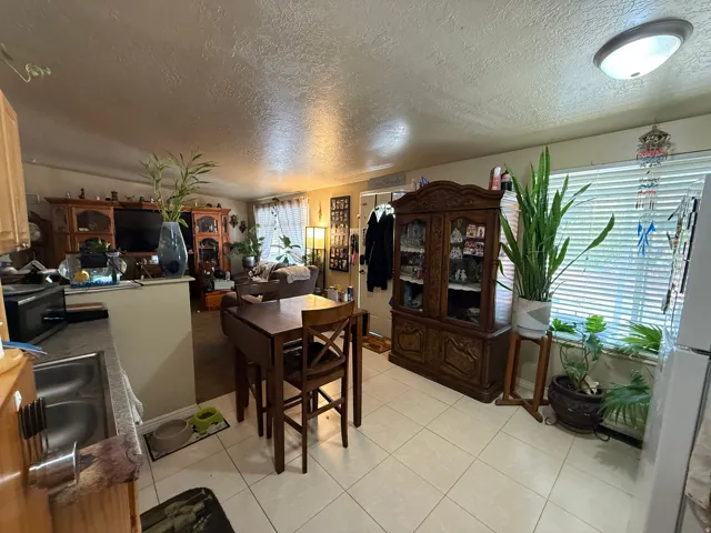 Kitchen area featuring light-toned tile flooring and a double-basin stainless steel sink