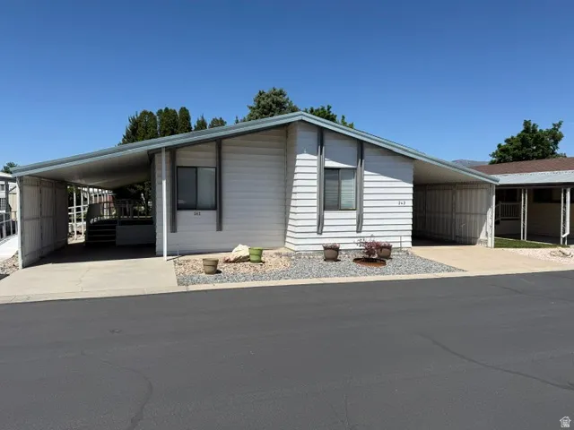 Residential building with light-colored siding and a carport