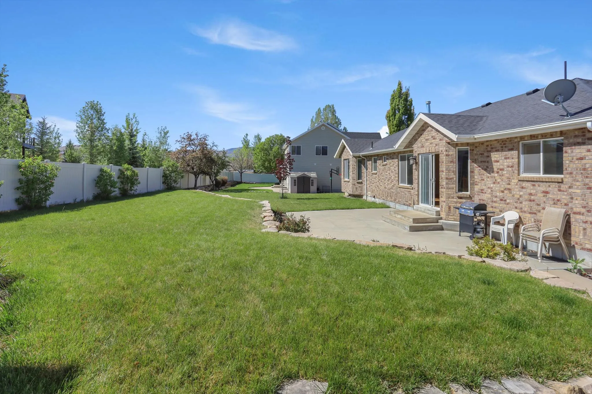 Expansive green lawn with a concrete patio