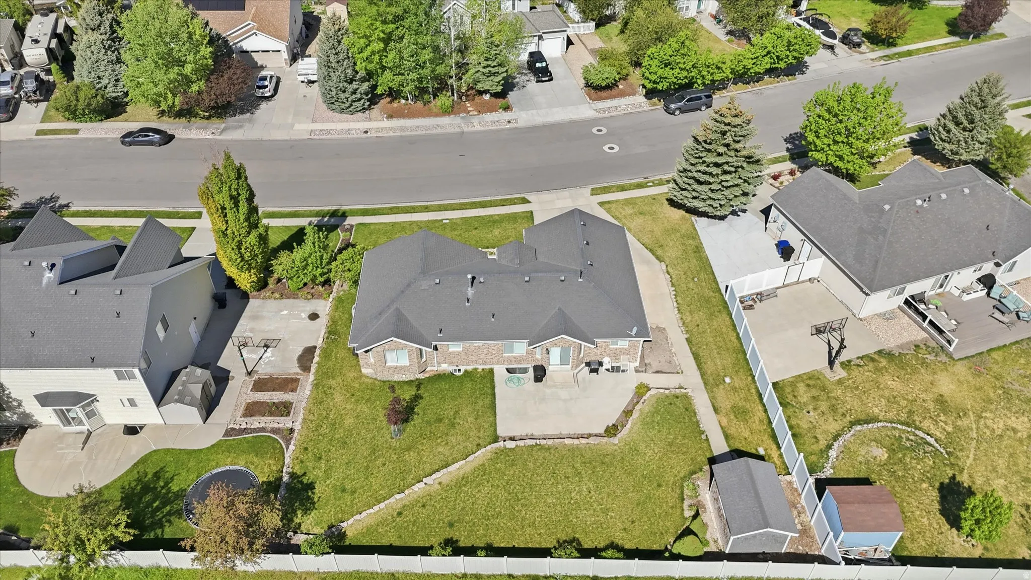 Expansive property featuring a brick and siding exterior, a large rear patio, mature landscaping, and a substantial grassy area