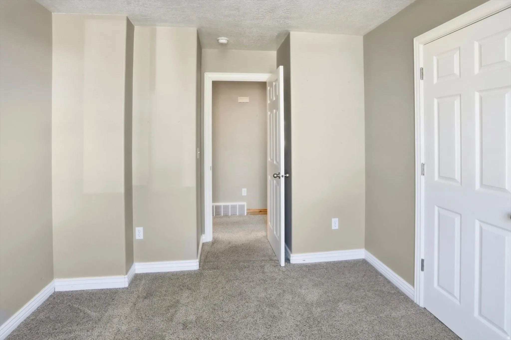 Neutral-toned walls complementing plush grey carpeting