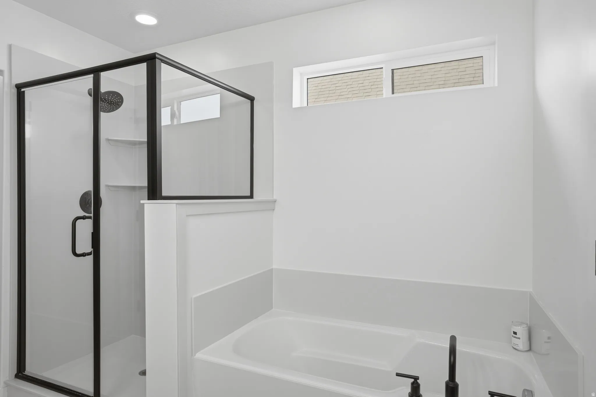 Contemporary bathroom featuring a walk-in shower with black-framed glass enclosure, built-in shelving, and a rain showerhead