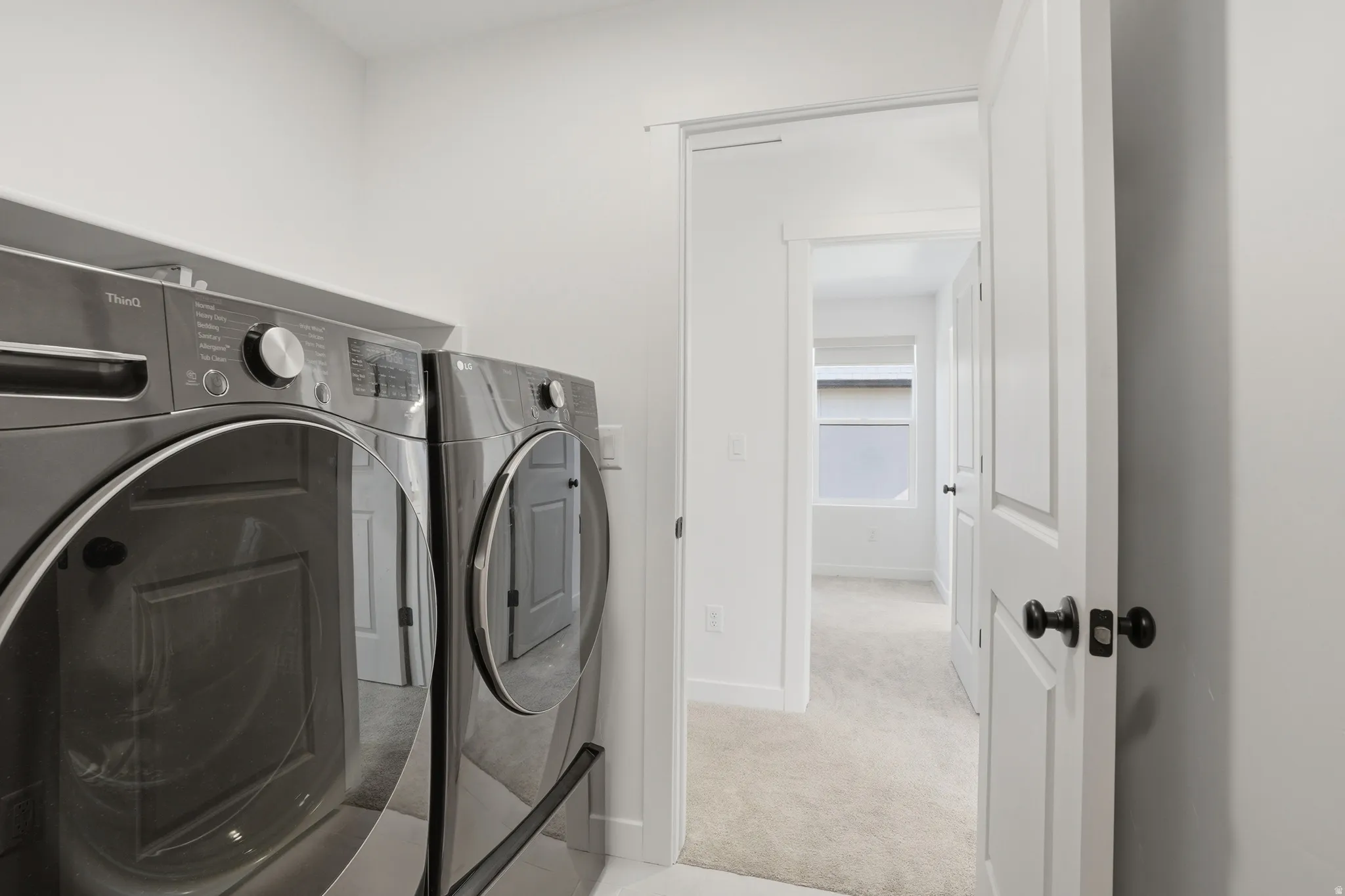 Dedicated laundry area with modern front-loading washer and dryer units