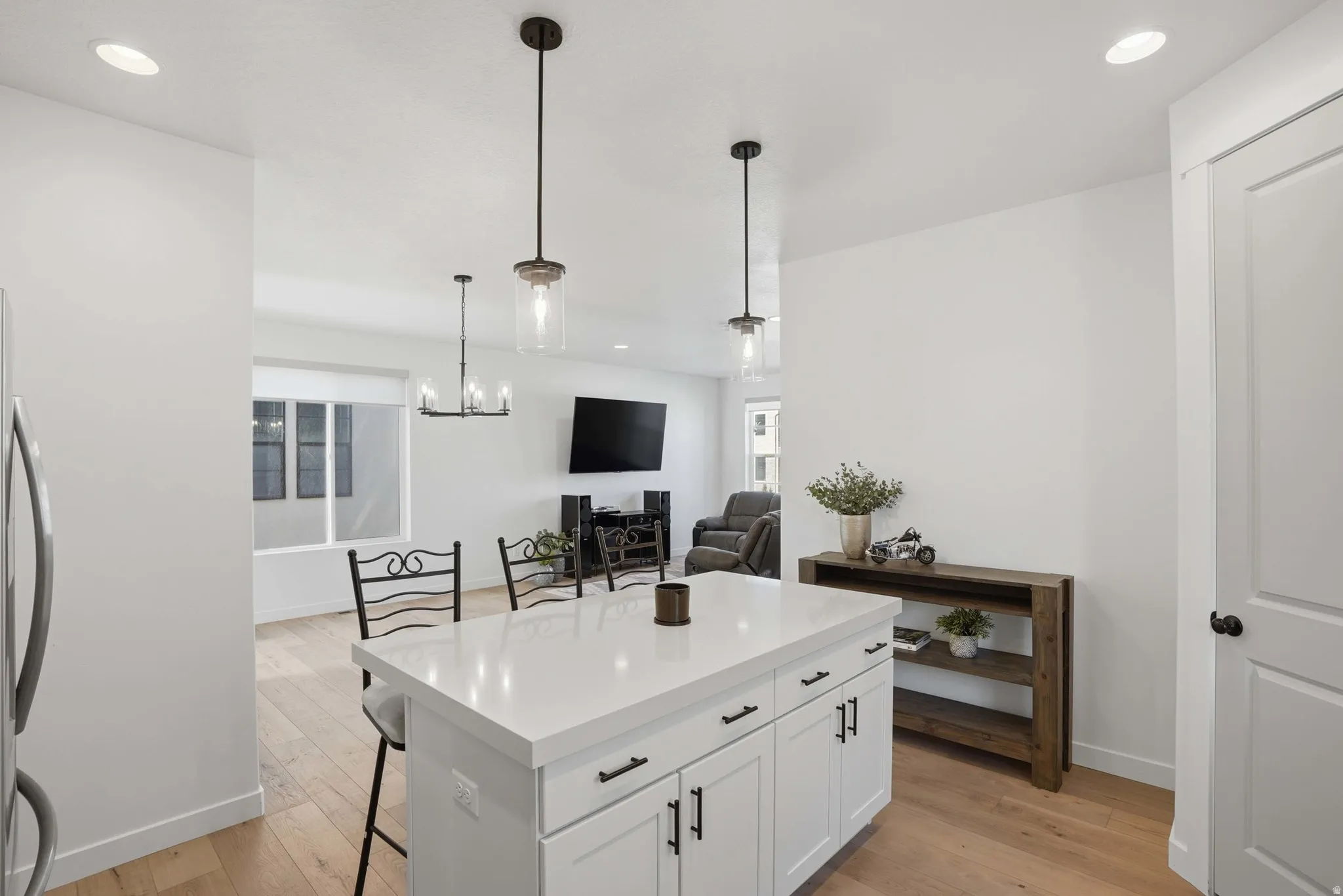 Kitchen island with white cabinetry and a light-toned countertop, featuring two pendant lights overhead