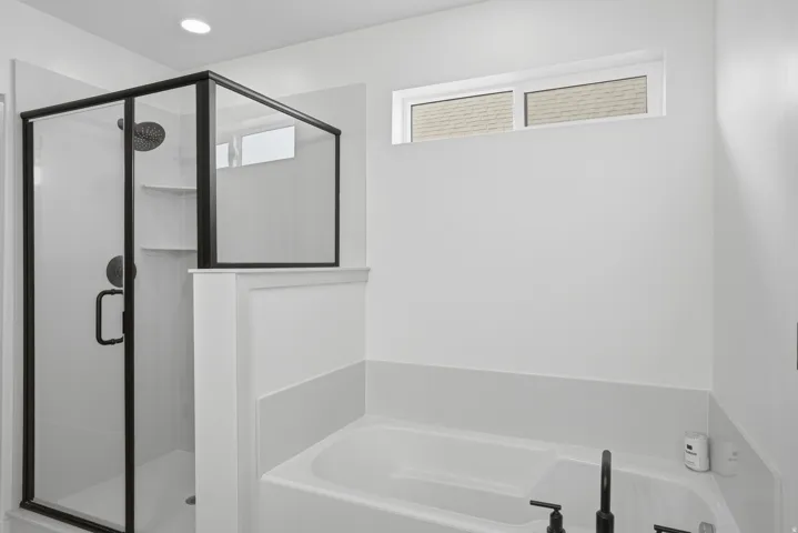 Contemporary bathroom featuring a walk-in shower with black-framed glass enclosure, built-in shelving, and a rain showerhead