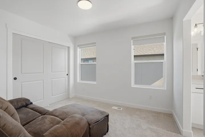 Bright interior space featuring light-colored carpeting, white walls, and a ceiling-mounted light fixture