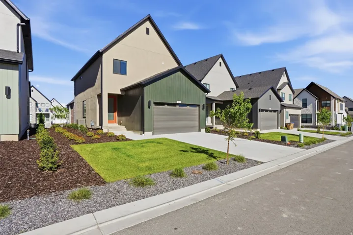 Modern architectural style with a two-car garage, concrete driveway, and a combination of stucco and vertical siding