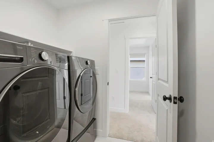 Dedicated laundry area with modern front-loading washer and dryer units