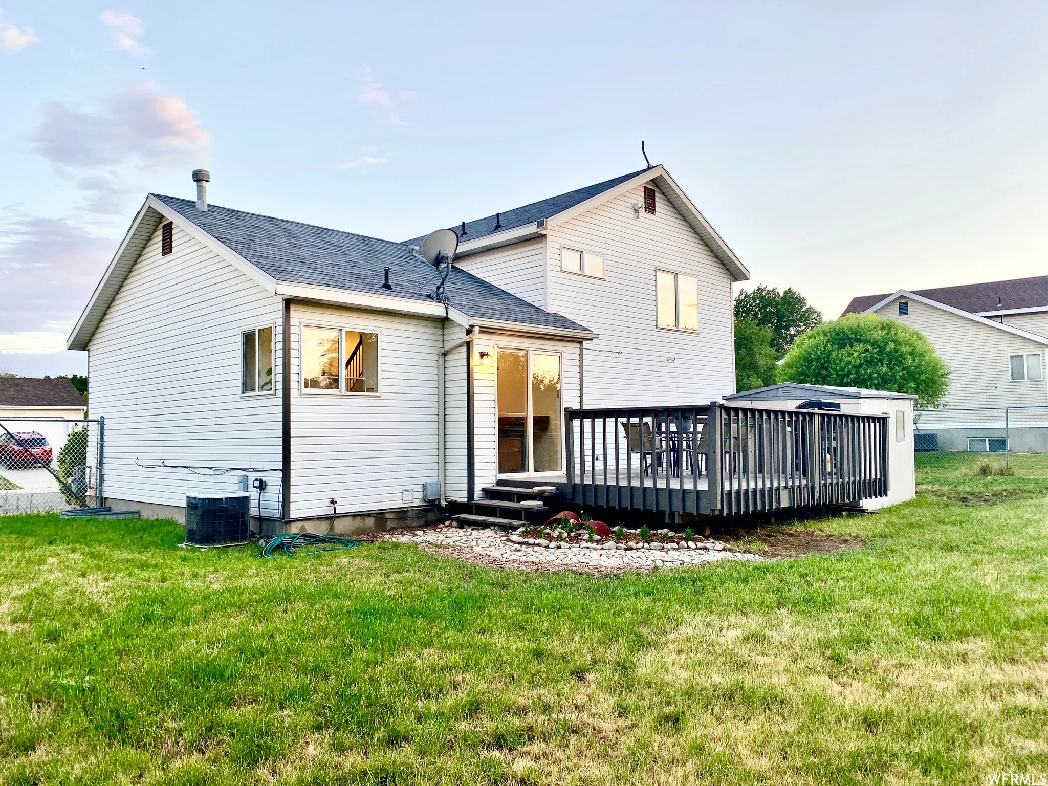 Rear exterior featuring white horizontal siding and a dark shingled roof