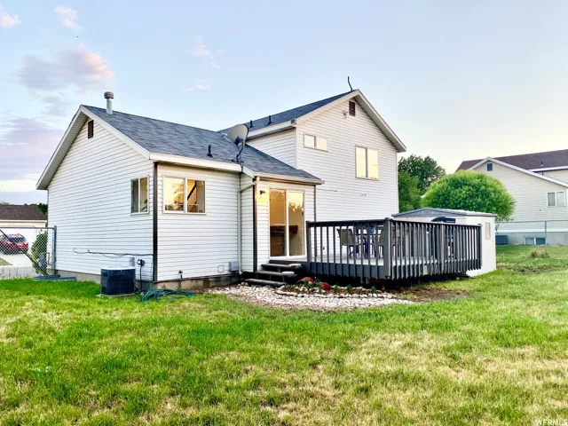 Rear exterior featuring white horizontal siding and a dark shingled roof
