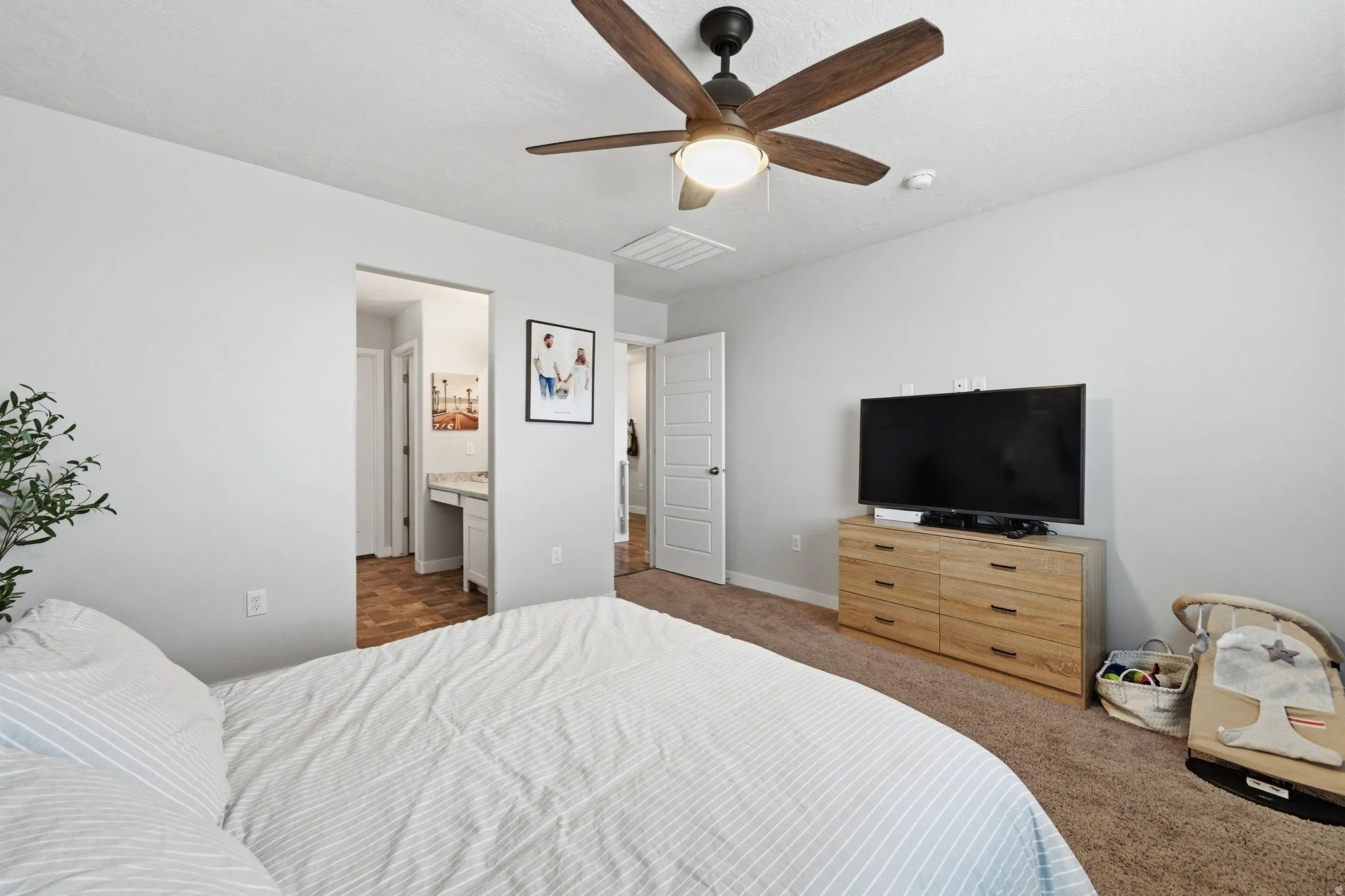 Bedroom featuring a ceiling fan with integrated lighting, light gray wall paint, and brown carpet flooring