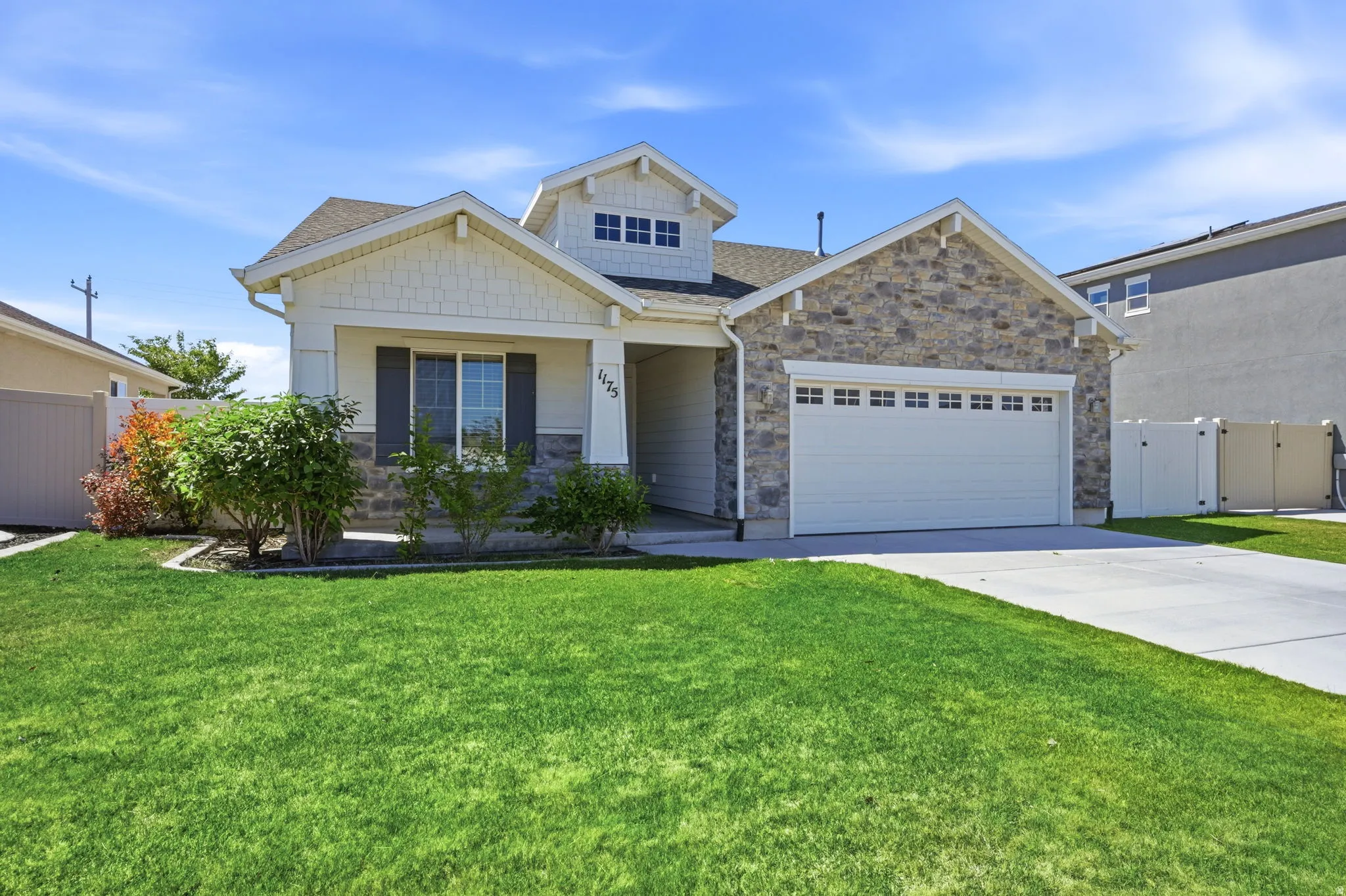 Stone and siding exterior with a prominent two-car garage