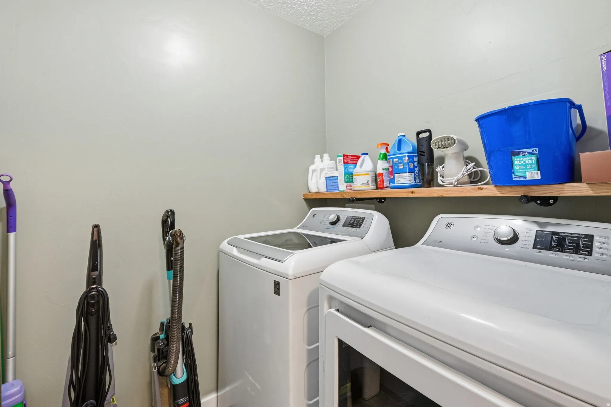 Dedicated laundry area featuring a full-size washer and dryer