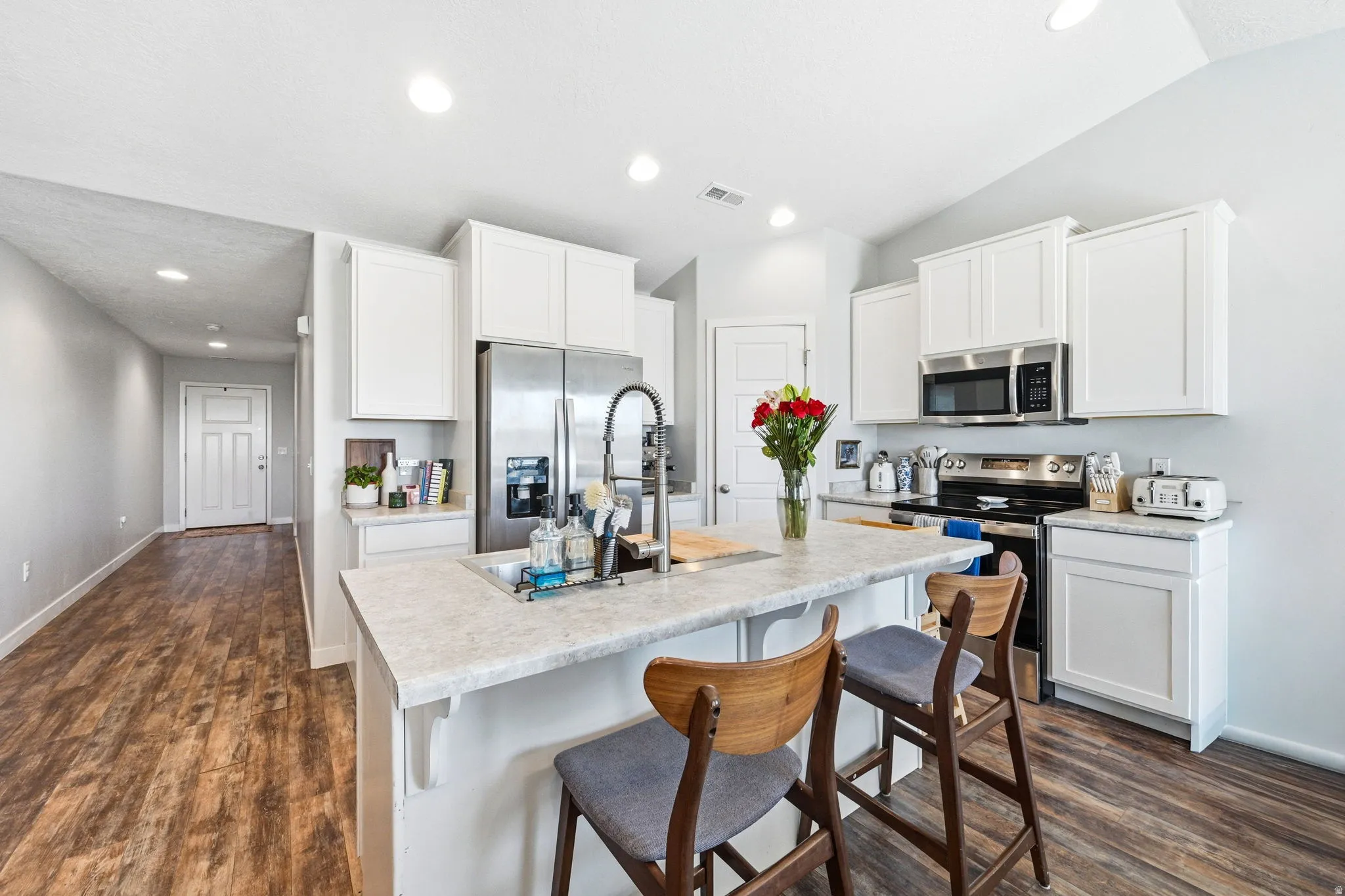 Modern kitchen featuring white shaker cabinetry and stainless steel appliances