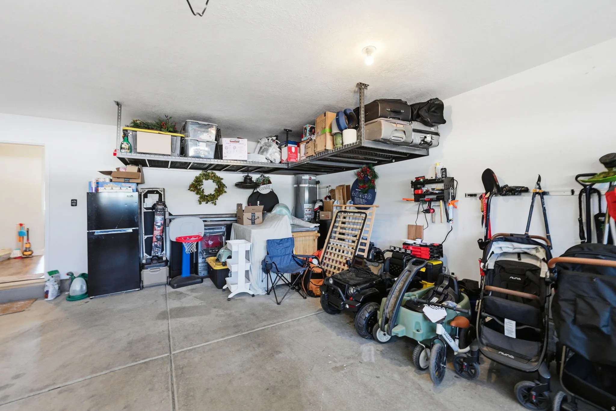 Garage featuring concrete flooring and overhead steel shelving