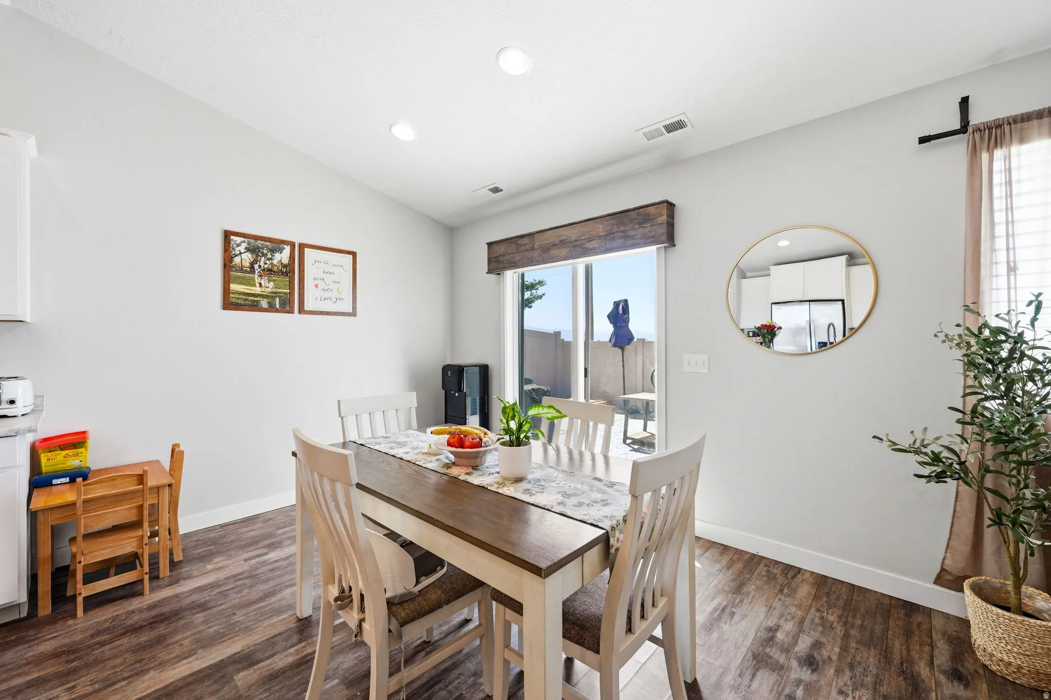 Dining area featuring wood-finish flooring, a sliding glass door, recessed lighting, and a neutral wall color