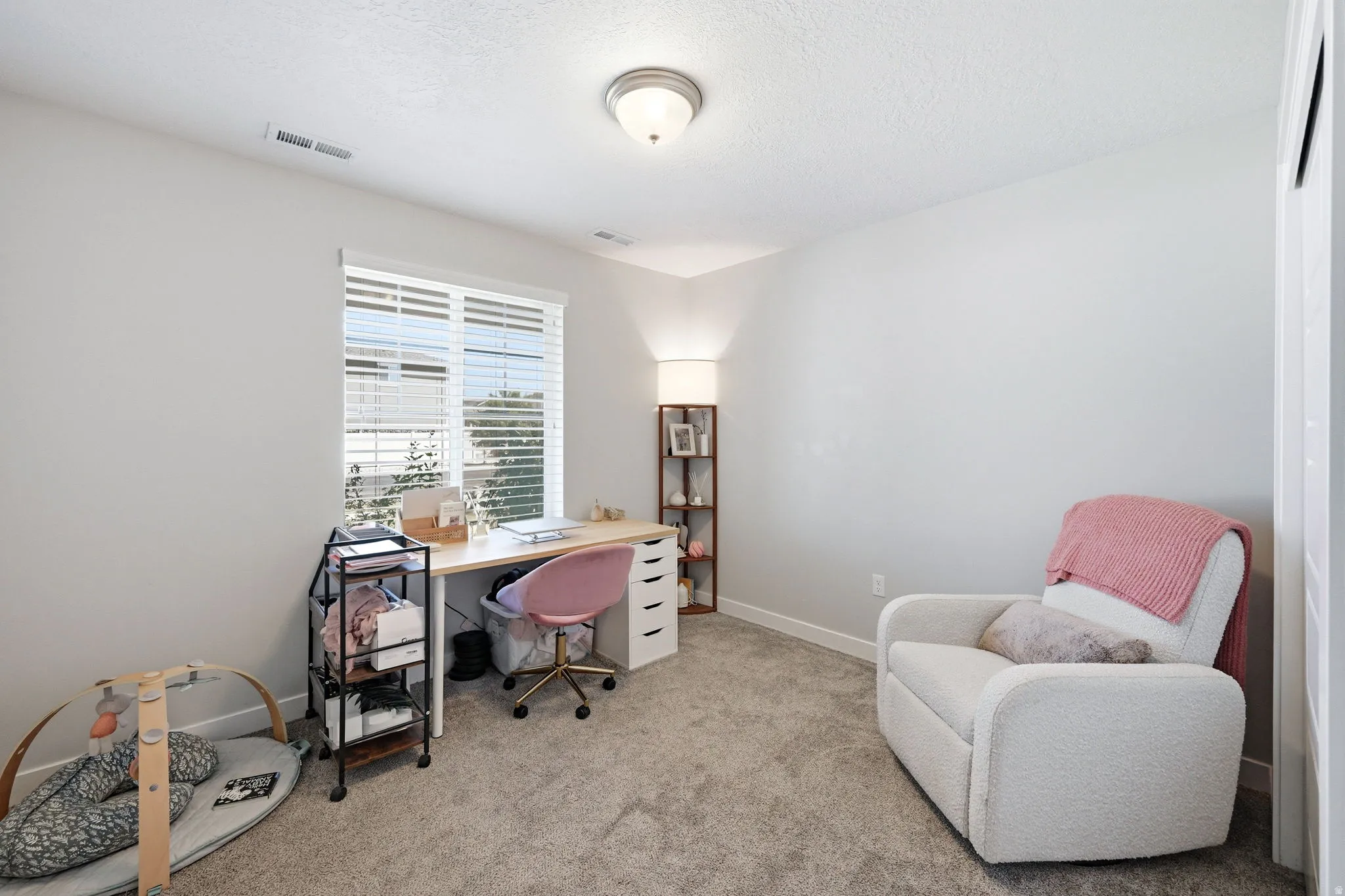 Room featuring neutral wall paint, carpet flooring, a window with horizontal blinds, and a flush mount ceiling light fixture
