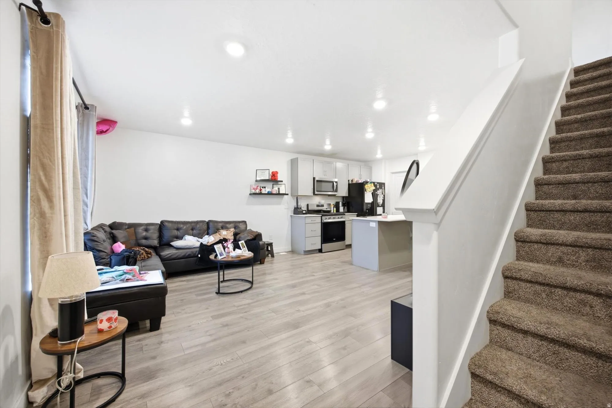 Open-concept living space featuring wood-finish flooring, recessed lighting, and a built-in kitchen island