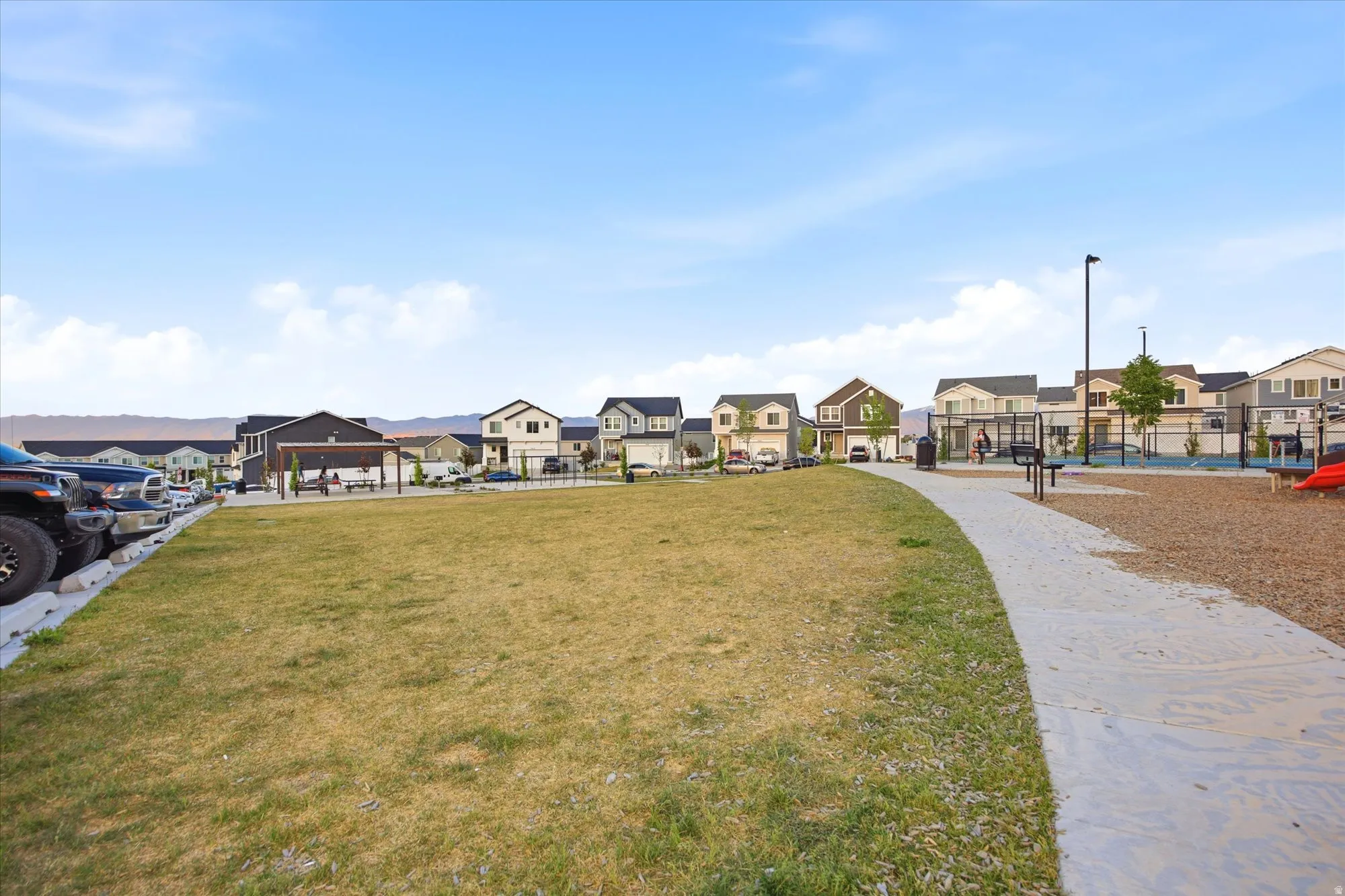Community green space featuring a gravel path and adjacent playground area with rubberized surfacing