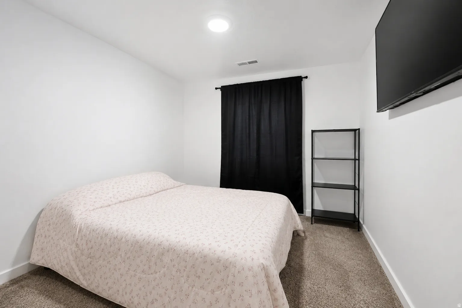 Bedroom featuring neutral carpeting, white walls, and a recessed ceiling light