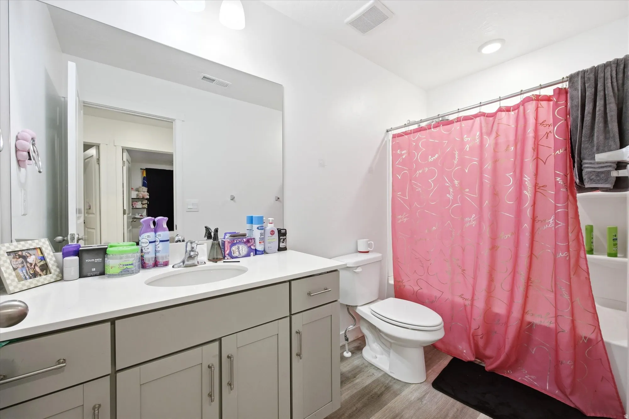 Bathroom with a light gray vanity, white countertop, integrated sink, and large wall-mounted mirror