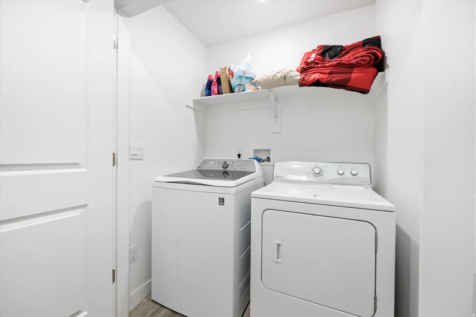 Dedicated laundry area featuring a top-load washing machine and a front-load dryer