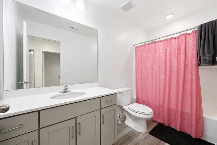 Bathroom featuring a single vanity with light grey cabinetry, a white countertop, and a built-in sink