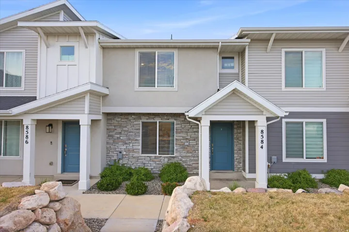 Modern facade featuring stone accents and light blue entry doors