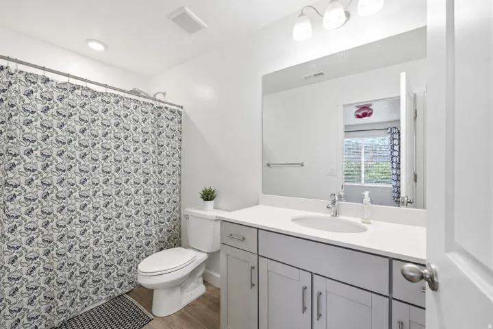 Bathroom featuring a vanity with an integrated sink, light-toned countertop, and light gray cabinetry with brushed nickel hardware