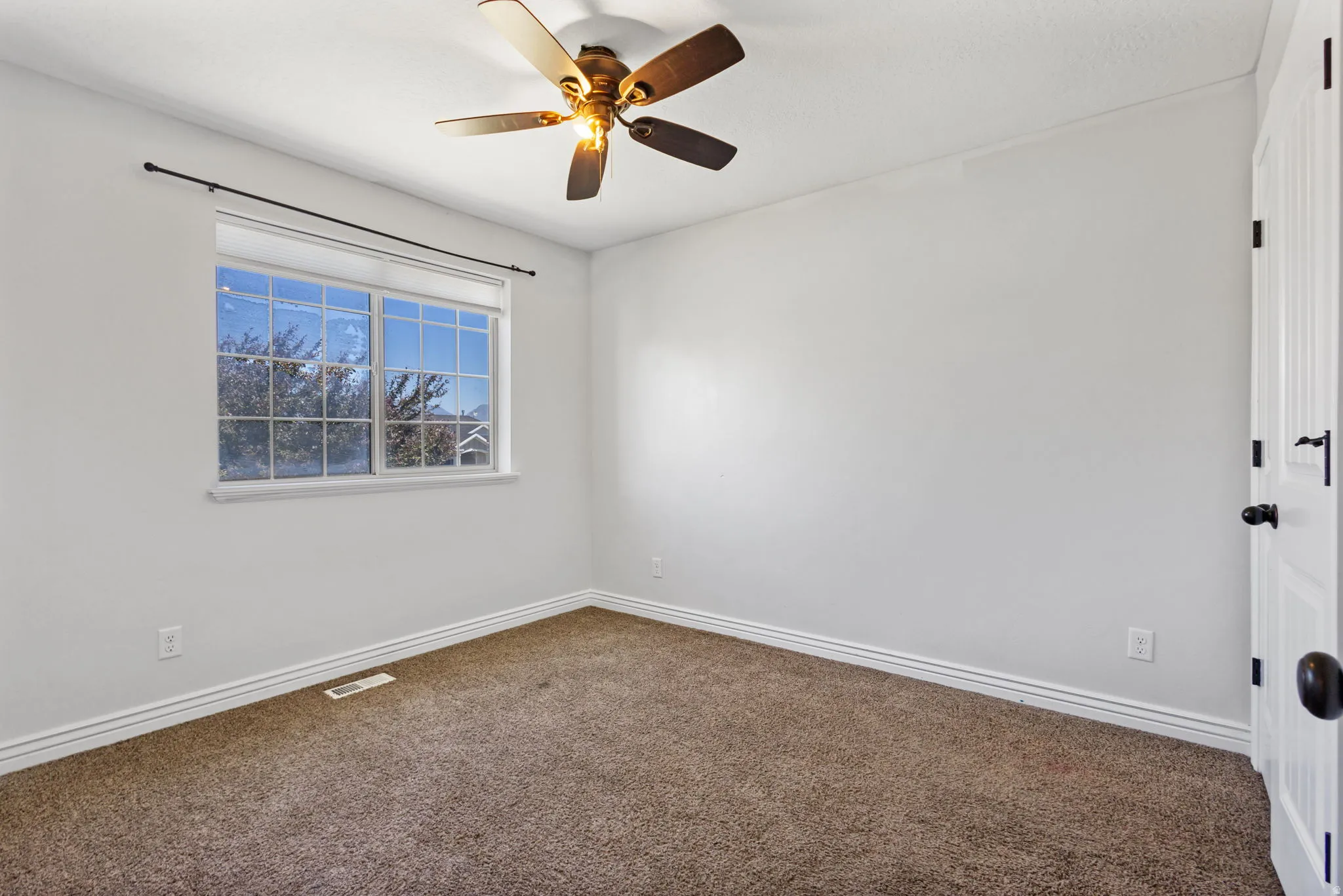 Recessed window featuring a black curtain rod, white trim, and a multi-pane design