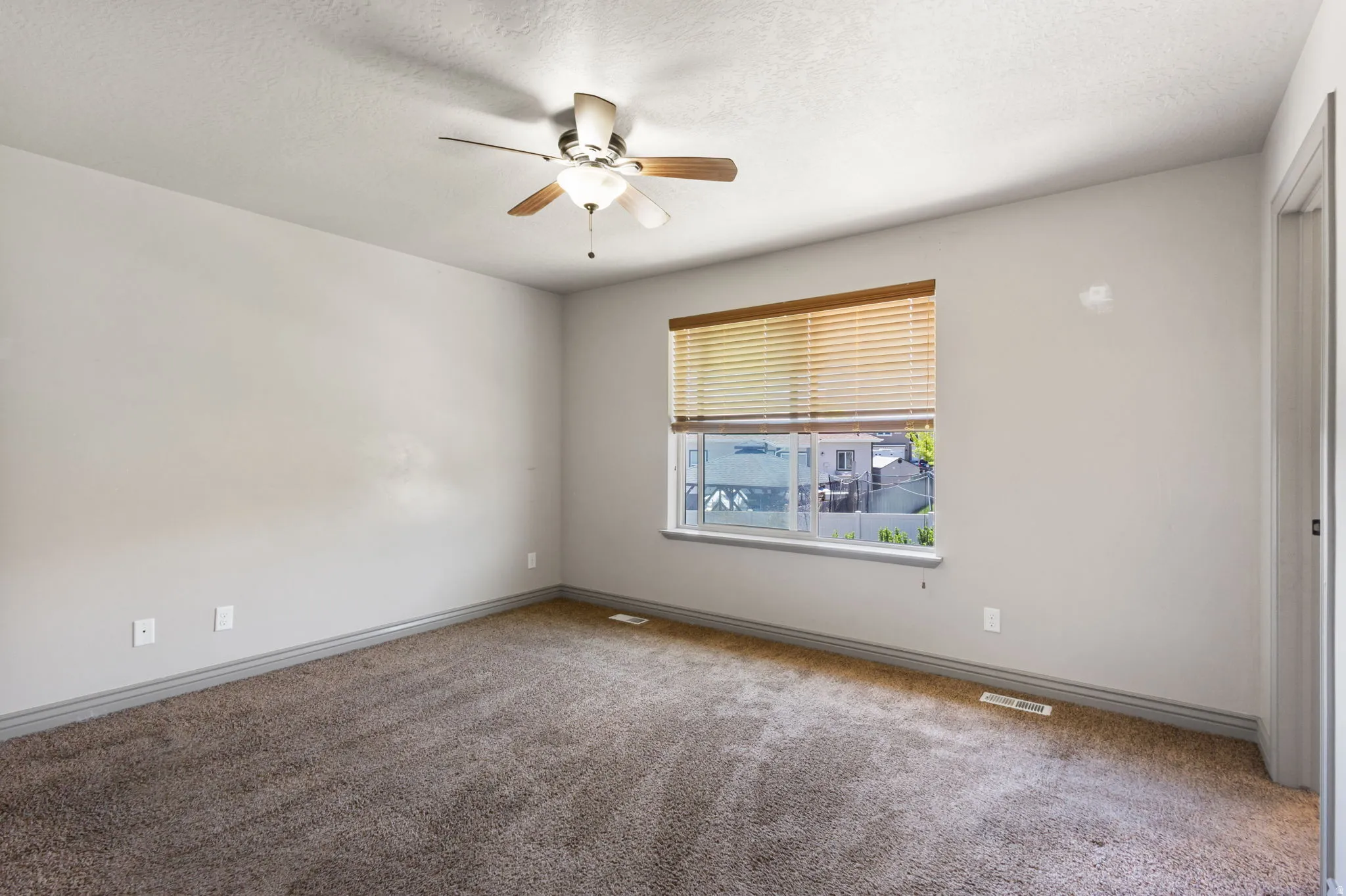Master bed room with a ceiling fan, a window with horizontal blinds, and light gray wall paint