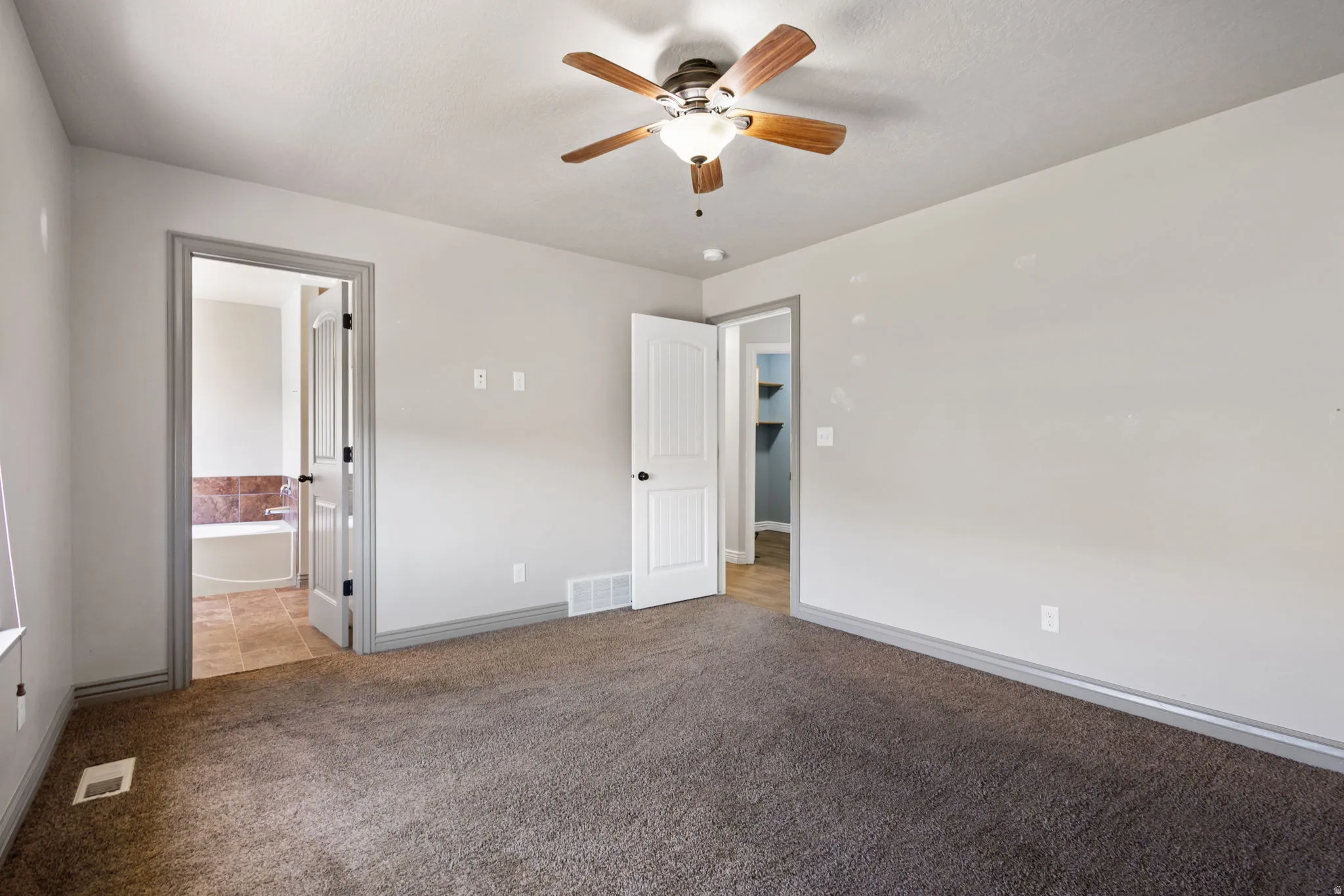 Master bed room with a ceiling fan light fixture